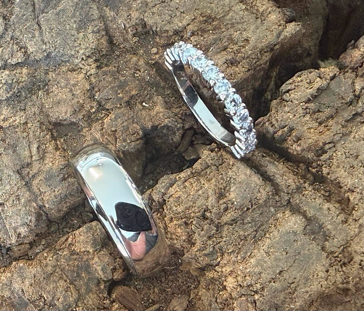 Two contrasting wedding-band designs on textured bark